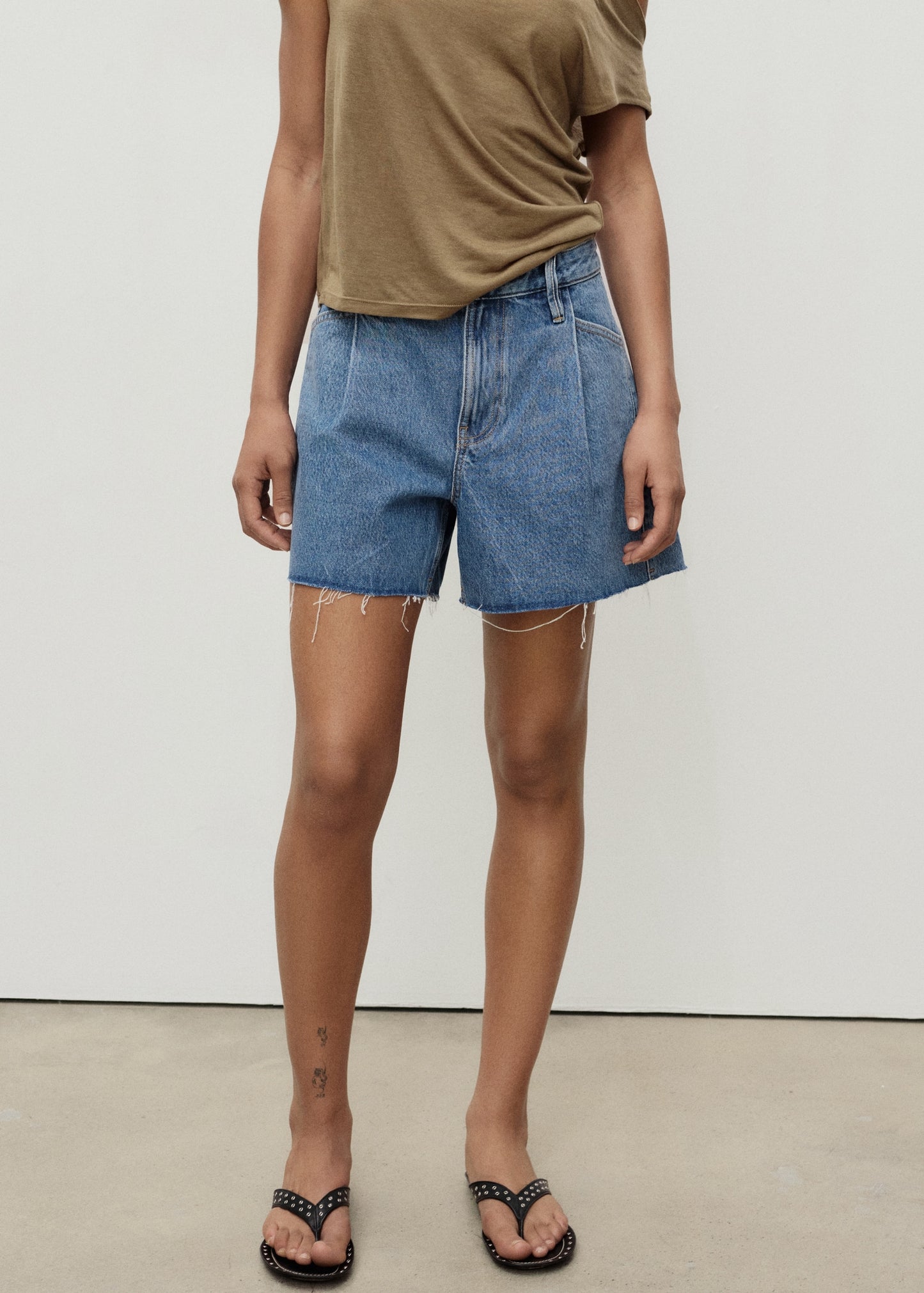 Denim shorts with frayed hem and pleats