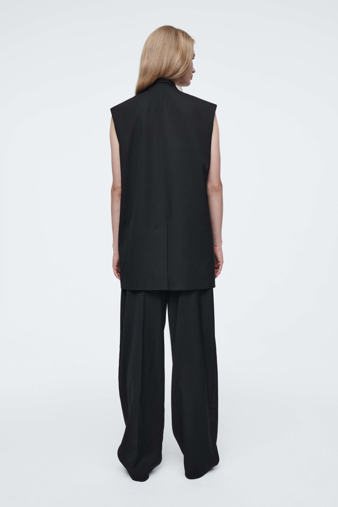 The elongated sleeveless blazer