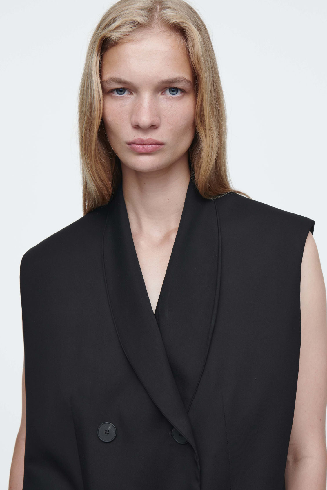 The elongated sleeveless blazer