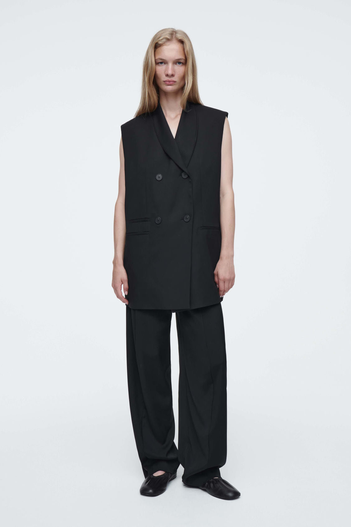 The elongated sleeveless blazer