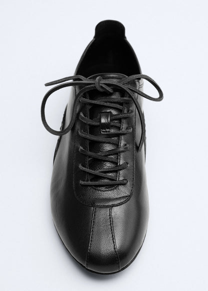 Leather trainer with stitched sole