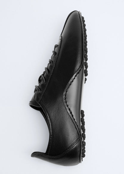 Leather trainer with stitched sole