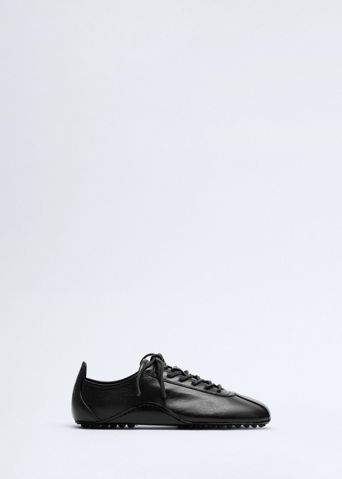 Leather trainer with stitched sole